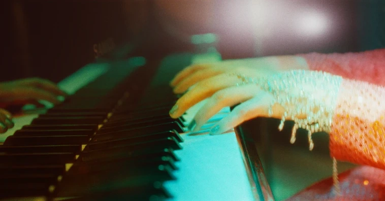 Las manos de Naty Borda sobre las teclas del piano, con el guante de pedrería